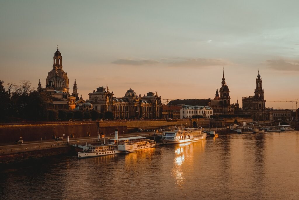 Dresden, Abends, Fluss mit Boot, im Hintergrund Gebäude von Dresden